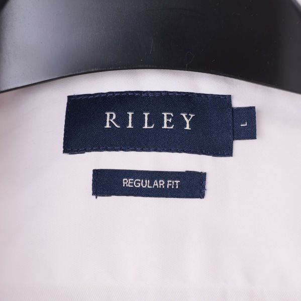 Närbild av RILEY-logga och storleksetikett i krage