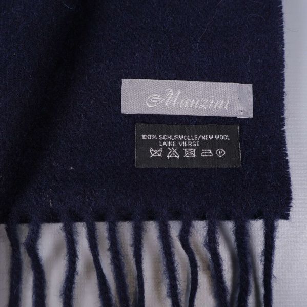 Närbild på Manzini etikett och ullmaterial