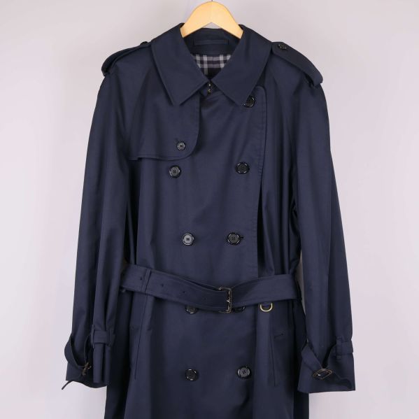 Närbild av trenchcoatens överdel och axelklaffar