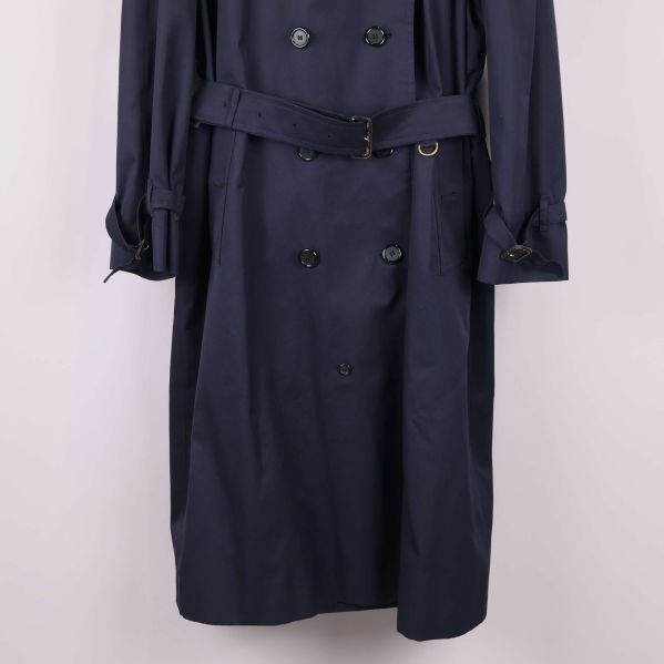 Närbild på trenchcoatens bälte och knäppning framtill