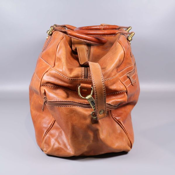 Sidovy av läderbag med axelrem och ytterficka med dragkedja