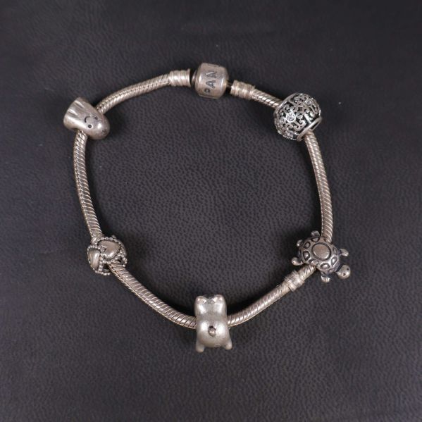 Charmarmband i silverfärg med olika pärlor uppifrån