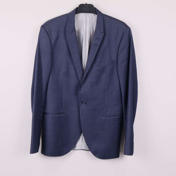 Helblå kostymkavaj hänger mot ljus bakgrund