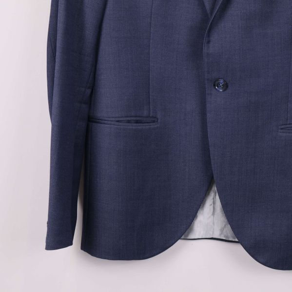 Närbild på nederdelen och fickor av blå kostymkavaj