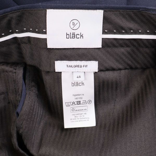 Etikett med Bläck-logotyp och storleksinformation inuti byxorna