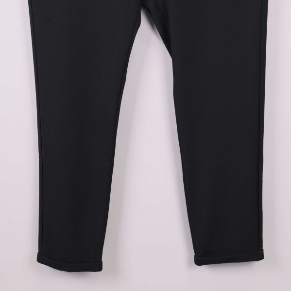 Nedre delen av svarta byxben med stilren kant