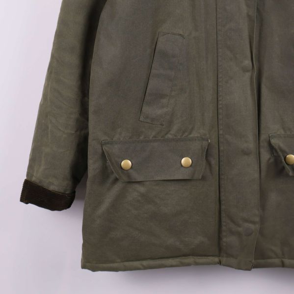 Närbild på jackficka med tryckknappar och manschett