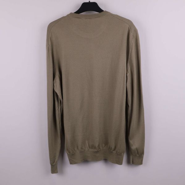 Baksidan av beige stickad tröja visas