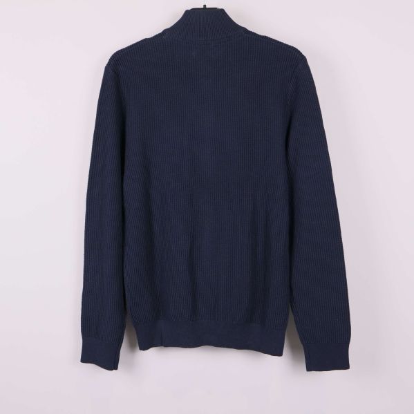 Mörkblå stickad ziptröja sedd bakifrån på galge