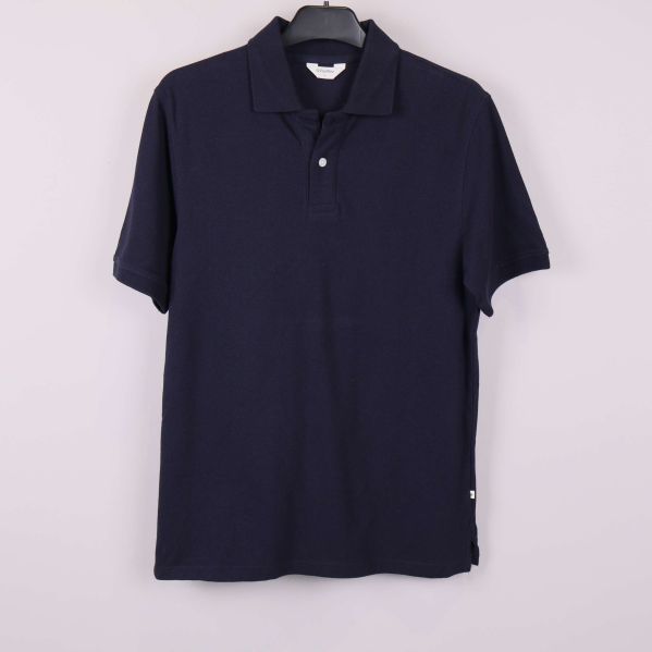 Mörkblå pikétröja framifrån på galge