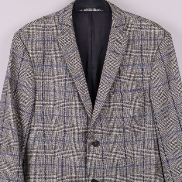 Närbild på övre delen av blazer med rutmönster och krage