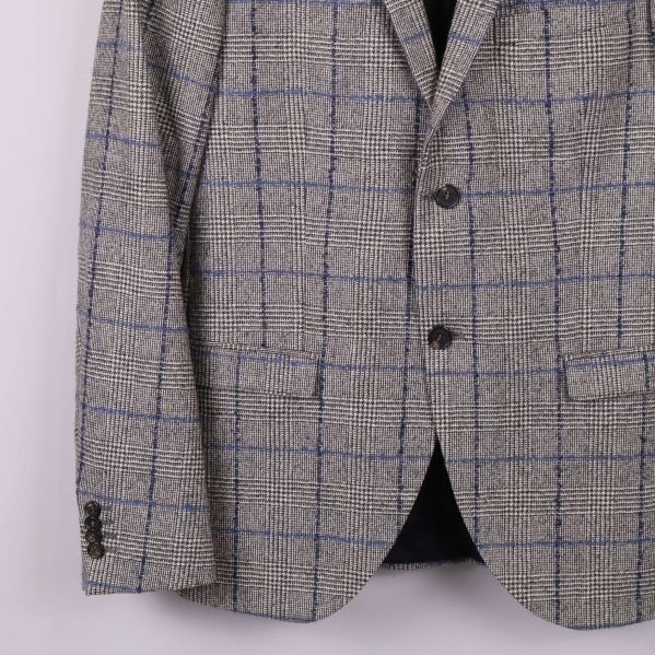 Närbild på blazer med framficka och knappar