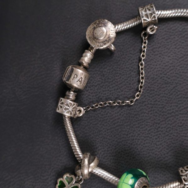 Närbild på berlock med text och silverkedja