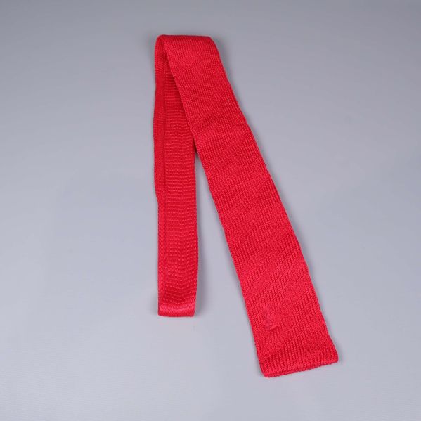 Slips i rött stickat material utlagd på bord