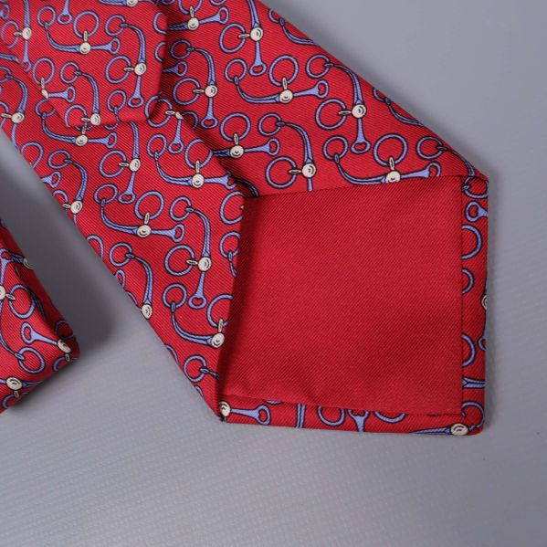 Detaljbild på röd slips med slät ena spets