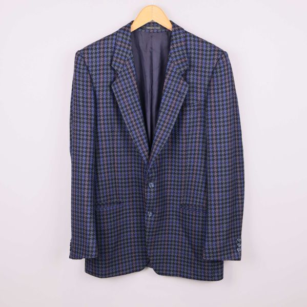 Kavaj i blått hundtandsmönster upphängd på galge framifrån