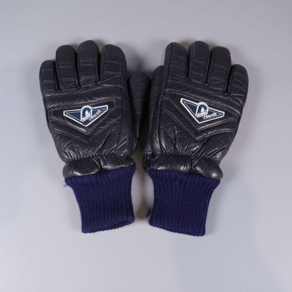 Handskar i svart med blå mudd liggande sida vid sida