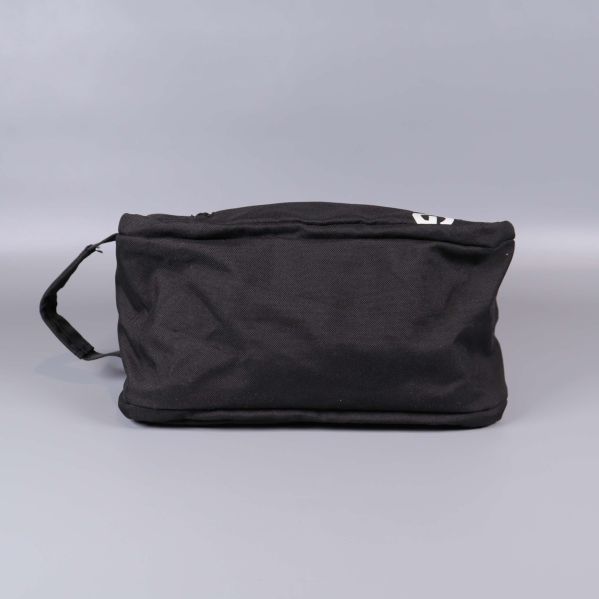 Necessär i svart tyg sedd underifrån med handtag åt vänster
