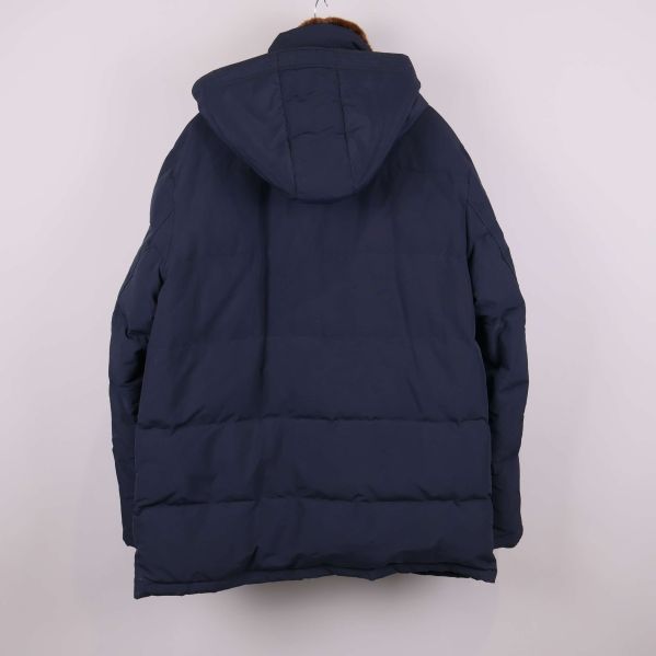 Baksida av mörk jacka med huva mot vit bakgrund