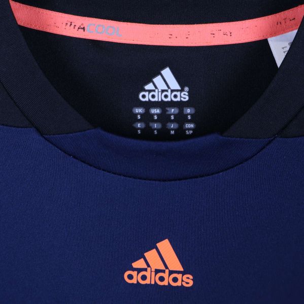 Närbild av Adidaslogga och Infinitex-märkning i kragen