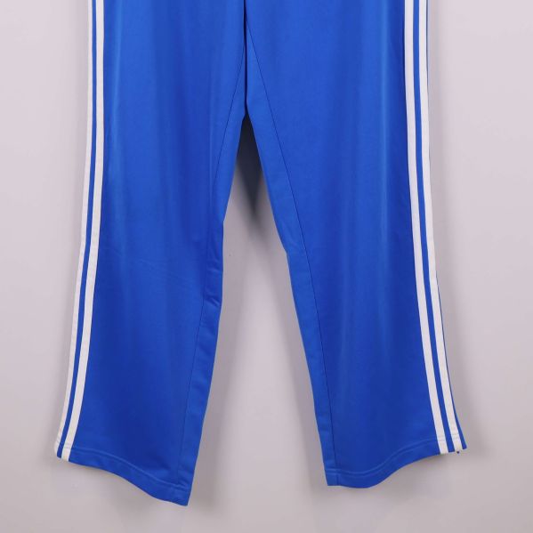 Närbild på benslut och sidoremsor på blå byxa