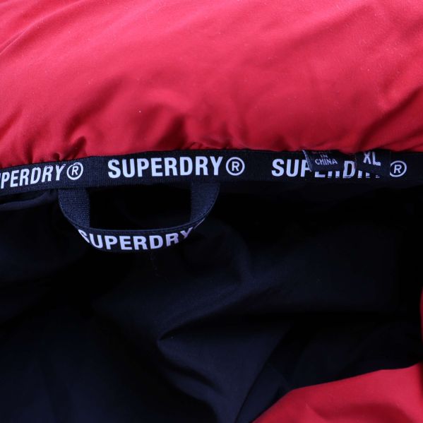 Insida av jacka med svart foder och Superdry-etikett