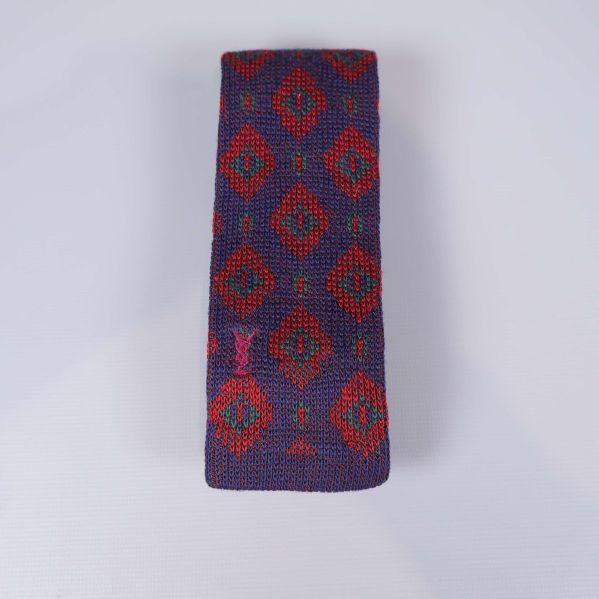 Stickad slips med grafiskt rött mönster på lila botten