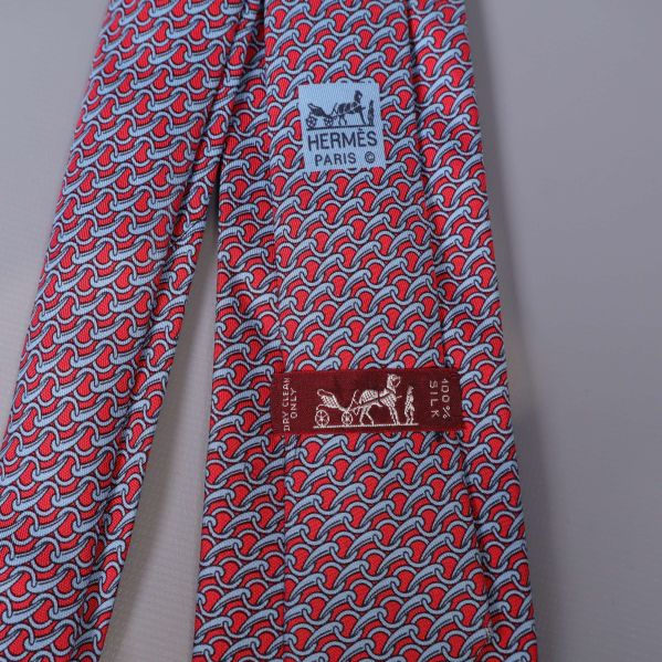 Närbild på Hermès-etikett och mönster på slips