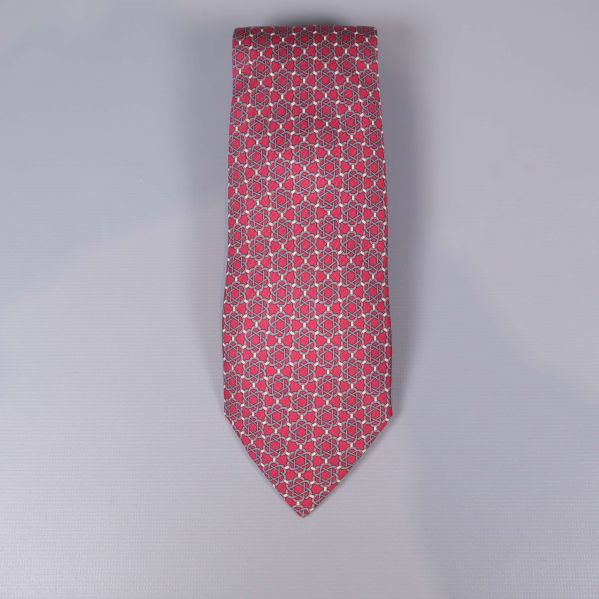 Röd slips med blått och vitt grafiskt mönster framifrån