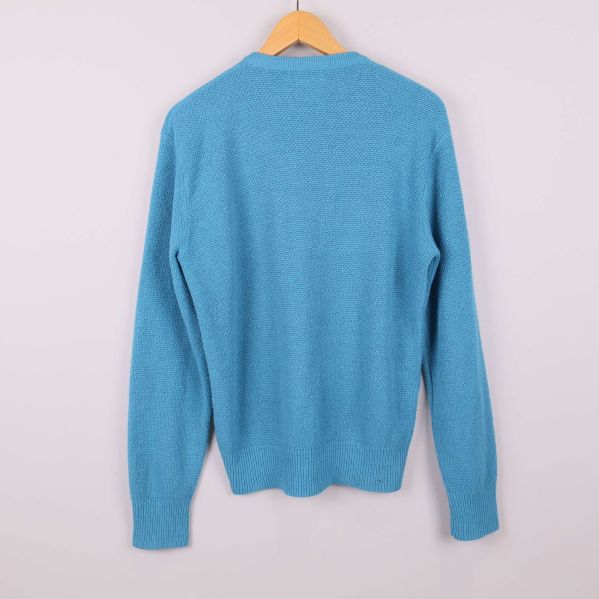 Baksidan av blå V-ringad stickad tröja 