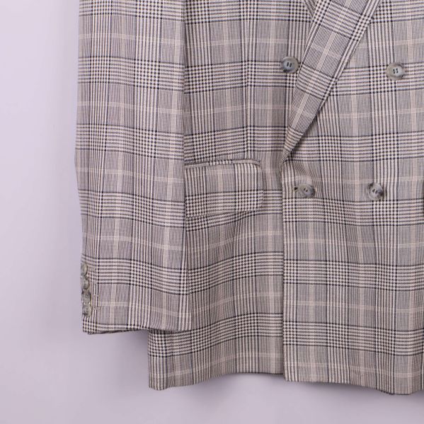 Nedre del och ärmslut på rutig kavaj med knappar