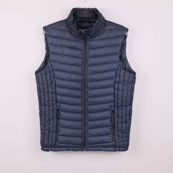 Framsida av blå quiltad väst med ståkrage och dragkedja