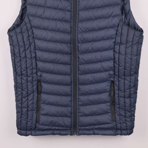 Närbild av västens nederdel med fickor och dragkedjor