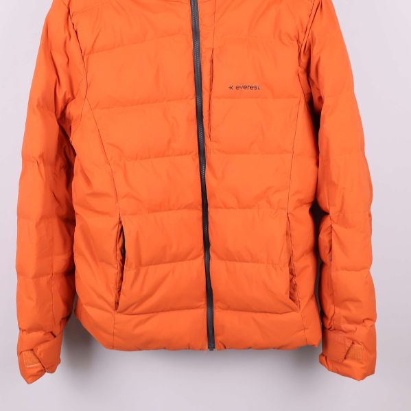 Närbild på nedre delen av orange jacka och fickor