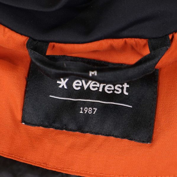 Närbild på Everest-märke och storlek M i jackans krage