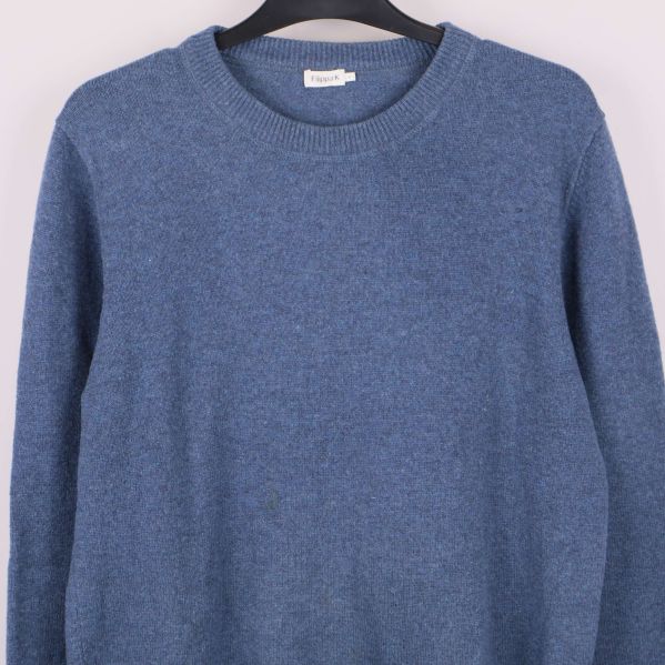 Övre del av blå stickad tröja med ribbade detaljer