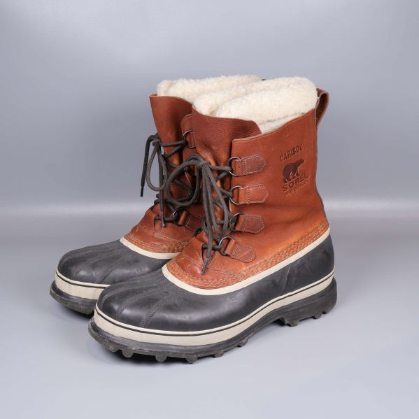 Vinterkängor med brun ovandel, svart sula och vitt foder i sidovy