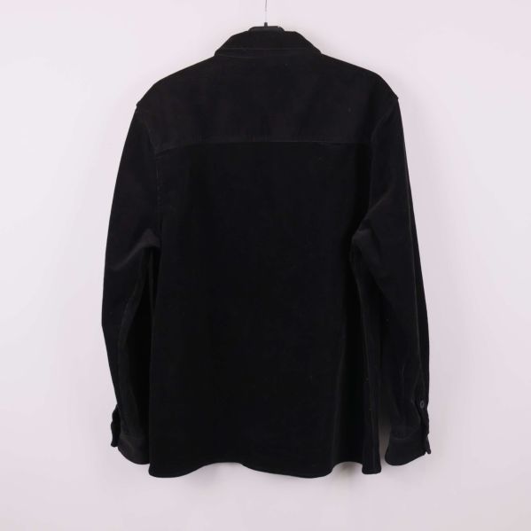 Svart manchesterskjorta sedd bakifrån på galge