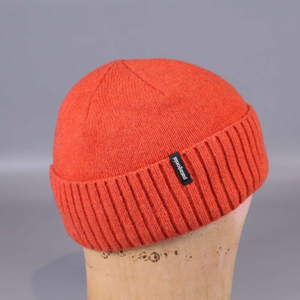 Sidovy av orange mössa på skyltdocka med logga