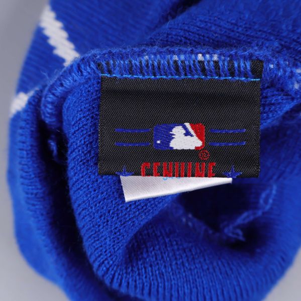 Svart etikett med MLB-logga och texten Genuine på mössans insida