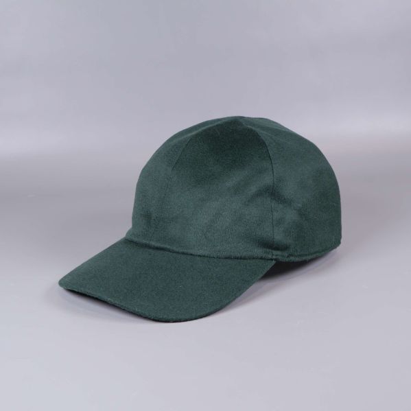 Grön keps i kashmir sedd snett framifrån på ljus bakgrund