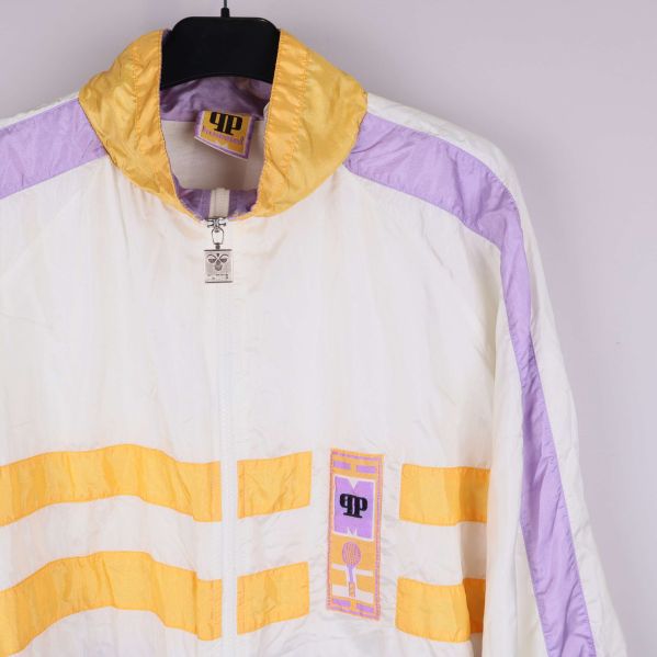 Detalj kring dragkedja och krage i gult, vitt och lila