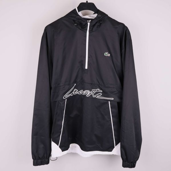 Svart och vit Lacoste vindjacka med huva hänger på galge