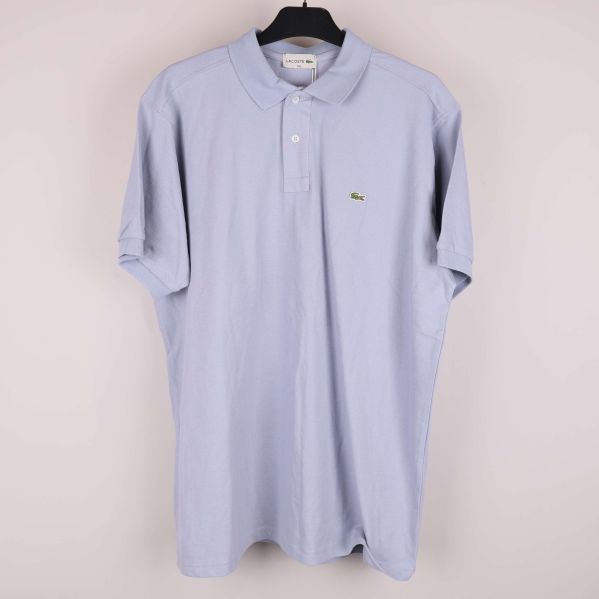 Ljusblå pikétröja med krage och krokodillogga på bröstet