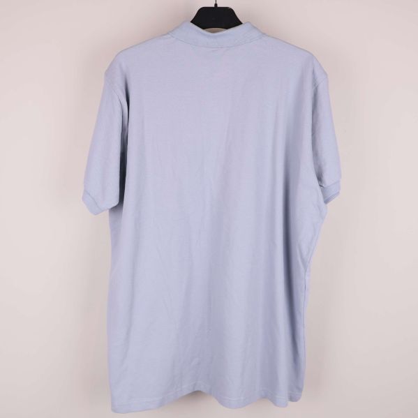 Baksidan av ljusblå pikétröja utan detaljer