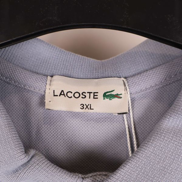 Närbild på Lacoste-etikett med storlek 3XL synlig