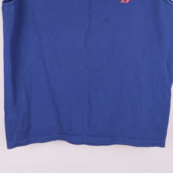 Nederkant av blå ärmlös topp visas i närbild