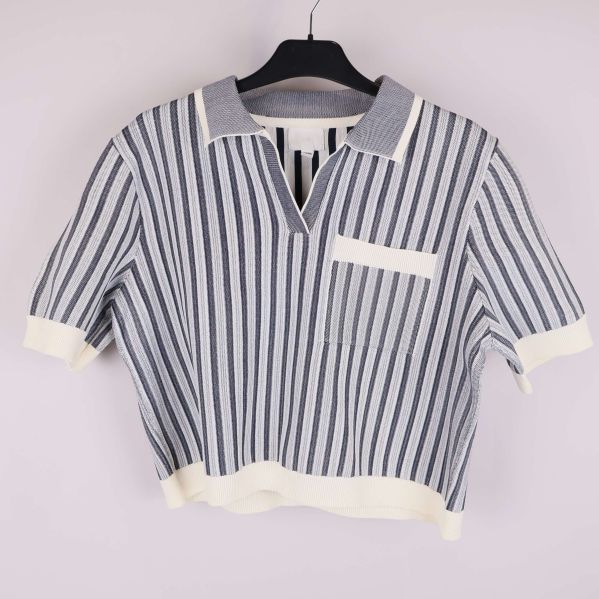 Stickad topp med blå och vita vertikala ränder på galge