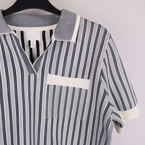 Närbild på bröstficka och krage på stickad topp