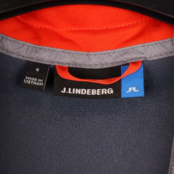 Närbild på J.Lindeberg märkning och storleksetikett i nacken